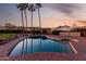 Sparkling pool surrounded by mature palm trees and desert landscaping offers a serene outdoor oasis at 12222 S Appaloosa Dr, Phoenix, AZ 85044