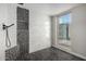 Modern shower with decorative black pebble tile accent and window with natural light at 12222 S Appaloosa Dr, Phoenix, AZ 85044