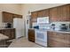 Traditional kitchen featuring wood cabinets, granite countertops, and white appliances at 12323 W Fieldstone Dr, Sun City West, AZ 85375