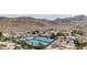 Community aerial showcasing tennis courts, pools, and houses framed by desert mountains at 13234 N 2Nd St, Phoenix, AZ 85022