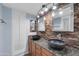 Modern bathroom features double sinks with stone accent wall and updated granite counters at 13234 N 2Nd St, Phoenix, AZ 85022