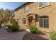 Charming tan two-story home with a well-manicured lawn, stone accents, and inviting entryway at 1350 S Greenfield Rd # 1215, Mesa, AZ 85206