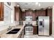 This kitchen features stainless steel appliances, neutral countertops and backsplash, a black sink and dark cabinets at 1350 S Greenfield Rd # 1215, Mesa, AZ 85206