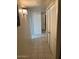 Hallway featuring tiled floors, storage closet, and decorative sconce lighting at 150 W Tam Oshanter Dr, Phoenix, AZ 85023