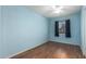 Bright bedroom with wood-look floors, a window with dark curtains, and a ceiling fan at 15811 N 23Rd St, Phoenix, AZ 85022