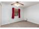 Cozy carpeted bedroom with neutral walls, ceiling fan, and a window with curtains at 15811 N 23Rd St, Phoenix, AZ 85022