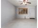 This living room features tile flooring, neutral walls, a ceiling fan, and a window with wood shutters at 15811 N 23Rd St, Phoenix, AZ 85022