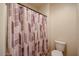 Bathroom shows a toilet and patterned shower curtain on a shower-tub combination at 1835 W Minton St, Phoenix, AZ 85041