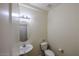 Cozy half bathroom with a pedestal sink, mirror, and toilet at 1835 W Minton St, Phoenix, AZ 85041