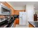 Modern kitchen with stainless steel appliances, dark backsplash, and wooden cabinets at 1835 W Minton St, Phoenix, AZ 85041