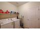 Practical laundry room with a washer, dryer, storage shelves, and a door at 1835 W Minton St, Phoenix, AZ 85041