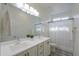 Bright bathroom featuring dual sinks, a large mirror, and a shower/tub combo with decorative tile accents at 1901 W 23Rd Ave, Apache Junction, AZ 85120