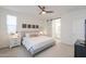 Bright bedroom with ceiling fan features light gray walls, white trim, and access to an en suite bath at 1901 W 23Rd Ave, Apache Junction, AZ 85120