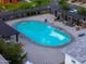 View of a community pool with seating, shade structures, and manicured landscaping at 1901 W 23Rd Ave, Apache Junction, AZ 85120