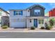 Charming two-story home featuring a blue front door, two car garage, and landscaped yard at 1901 W 23Rd Ave, Apache Junction, AZ 85120