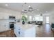 Well-lit kitchen with a center island, stainless appliances, and white cabinets, flowing into the living area at 1901 W 23Rd Ave, Apache Junction, AZ 85120