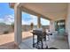 Covered patio featuring a gas grill and comfortable seating area overlooking the backyard at 1901 W 23Rd Ave, Apache Junction, AZ 85120