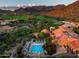 An aerial view showcasing a private pool, tile roofs and a sprawling golf course at 20299 N 102Nd Pl, Scottsdale, AZ 85255