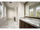 Elegant bathroom with marble floors, a large mirror reflecting natural light from the windows, and dual sink vanity at 20299 N 102Nd Pl, Scottsdale, AZ 85255