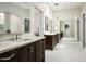 Bright bathroom featuring dual sinks, marble countertops, and a large mirror reflecting an organized walk-in closet at 20299 N 102Nd Pl, Scottsdale, AZ 85255