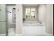 Spa-like bathroom featuring a soaking tub, tiled shower with rain shower head, and a window with natural light at 20299 N 102Nd Pl, Scottsdale, AZ 85255