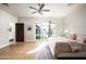 Bright bedroom featuring hardwood floors, a ceiling fan, and a glass door leading to the backyard at 20299 N 102Nd Pl, Scottsdale, AZ 85255