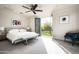 Serene main bedroom with a ceiling fan and access to a balcony offering views of lush greenery at 20299 N 102Nd Pl, Scottsdale, AZ 85255