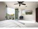 Relaxing main bedroom with balcony access offering scenic outdoor views, comfortable chair, and a mounted TV at 20299 N 102Nd Pl, Scottsdale, AZ 85255