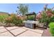 Outdoor grilling area featuring large grill surrounded by pink flowering bushes and a white fence at 207 W Clarendon Ave # H10, Phoenix, AZ 85013