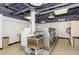 Well-lit laundry room features rows of washers and dryers and a large stainless steel utility sink at 207 W Clarendon Ave # H10, Phoenix, AZ 85013