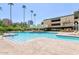 Community pool featuring clear blue water, lounge chairs, and sunny skies at 207 W Clarendon Ave # H10, Phoenix, AZ 85013