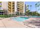 Community wading pool surrounded by fencing, lush landscaping, and large building at 207 W Clarendon Ave # H10, Phoenix, AZ 85013