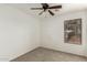 This bedroom features a ceiling fan and a sunlit window with neutral carpet flooring at 21397 N Goles Dr, Maricopa, AZ 85138