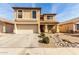 Charming two-story home featuring a tile roof, arched windows, and a two-car garage with a desert landscape at 21397 N Goles Dr, Maricopa, AZ 85138