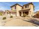 A detailed view of a two-story house highlighting the desert landscaping and two-car garage at 21397 N Goles Dr, Maricopa, AZ 85138