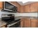 Close-up of kitchen appliances, showcasing stainless steel microwave, oven, and wooden cabinets at 21397 N Goles Dr, Maricopa, AZ 85138