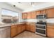 Well-lit kitchen with stainless steel appliances, wooden cabinets, and a double oven at 21397 N Goles Dr, Maricopa, AZ 85138