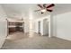 Open-concept living area combining carpet and tile, with kitchen view and storage options at 21397 N Goles Dr, Maricopa, AZ 85138