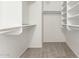 A bright walk-in closet with shelving and carpet providing optimal storage at 21397 N Goles Dr, Maricopa, AZ 85138