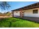 Backyard of a home featuring lawn, covered patio with brick pillars, and clear blue sky at 2142 E Palmcroft Dr, Tempe, AZ 85282