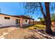 Covered patio and backyard with desert landscaping and mature tree at 2142 E Palmcroft Dr, Tempe, AZ 85282
