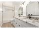 Bright bathroom features double vanity with granite countertop, black fixtures, tiled shower and bathtub at 2142 E Palmcroft Dr, Tempe, AZ 85282