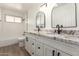 Modern bathroom with double vanity, granite countertops, black fixtures, and a tiled tub/shower combo at 2142 E Palmcroft Dr, Tempe, AZ 85282