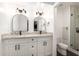 Bright bathroom featuring double vanity with granite countertop, arched mirrors, and tiled shower at 2142 E Palmcroft Dr, Tempe, AZ 85282