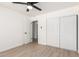 Clean bedroom with wood floors, ceiling fan, closet, and view to hallway through an open door at 2142 E Palmcroft Dr, Tempe, AZ 85282
