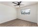 This bedroom offers hardwood flooring, a ceiling fan, and a window for ample natural light at 2142 E Palmcroft Dr, Tempe, AZ 85282