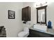 Stylish half bathroom with a modern sink, decorative mirror, and elegant light fixture at 22211 N 51St St, Phoenix, AZ 85054