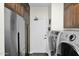 Well-lit laundry room features a modern washer and dryer and plenty of cabinet space at 22211 N 51St St, Phoenix, AZ 85054