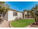 Home's backyard features desert landscaping, a covered patio, and a well-maintained lawn at 22288 S 214Th S St, Queen Creek, AZ 85142