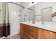 Bright bathroom featuring a dual sink vanity, large mirror, and shower-tub combo at 22288 S 214Th S St, Queen Creek, AZ 85142